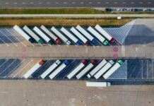 EU approves new sustainable supply chain rules An arial view looks down on parked transporter trucks.