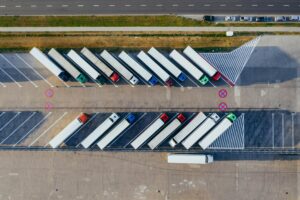 An arial view looks down on parked transporter trucks.