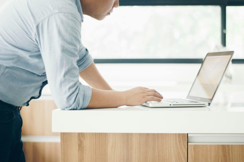 A mean leans over his laptop, looking focused as he tried to access the ESOS IT portal