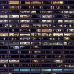 ISO 50001 for ESOS compliance: important change An office building is lit up at night, showing the empty rooms inside.