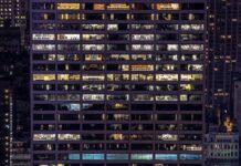 ISO 50001 for ESOS compliance: important change An office building is lit up at night, showing the empty rooms inside.