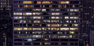 ISO 50001 for ESOS compliance: important change An office building is lit up at night, showing the empty rooms inside.