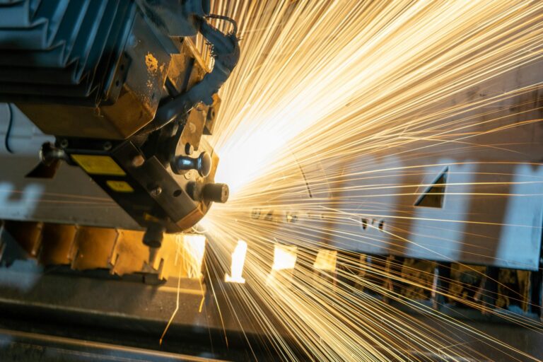 A machine in a manufacturing company lets off a large, bright flurry of sparks.