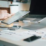 UK election: Businesses call for stronger net zero support A person works at their desk, with a laptop, tablet, and calculator