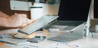 UK election: Businesses call for stronger net zero support A person works at their desk, with a laptop, tablet, and calculator