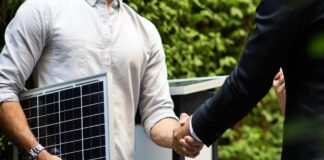 Labour’s first month: Key energy sector changes so far Two men in semi-professional attire shake hands, while one is holding a small sample of solar panel technology