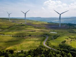 Strategic Innovation Fund to receive more funding for UK decarbonisation Wind turbines on the horizon stand above green hills in Wales