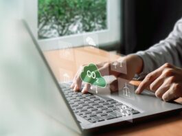 Understanding ESG: Environmental, Social, and Governance A man types on his computer, working on an ESG report. Symbols hover above his keyboard in a futuristic way, including symbols such as windmills and a CO2 cloud.