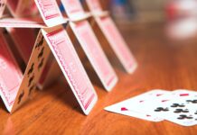 Is the government’s BECCS strategy a house of cards? A house of cards on a brown table, which may be symbolic of the government's BECCs strategy, according to the article.