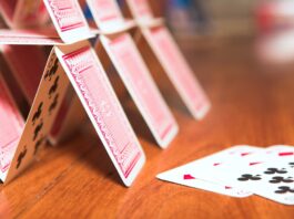 Is the government’s BECCS strategy a house of cards? A house of cards on a brown table, which may be symbolic of the government's BECCs strategy, according to the article.