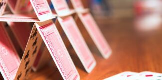 Is the government’s BECCS strategy a house of cards? A house of cards on a brown table, which may be symbolic of the government's BECCs strategy, according to the article.