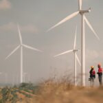 UK hits historic 30GW milestone of wind generation capacity Two people stand in a wind farm field
