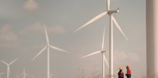 UK hits historic 30GW milestone of wind generation capacity Two people stand in a wind farm field