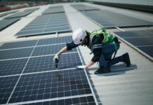 IEA: Renewables to power half of world’s electricity by 2030 but miss COP28 goals A man on the roof of a building installs solar panels.