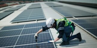 IEA: Renewables to power half of world’s electricity by 2030 but miss COP28 goals A man on the roof of a building installs solar panels.