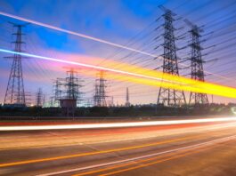 What’s next for the Demand Flexibility Service? Car lights blur in front of power lines as the sun sets in the distance.
