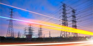 What’s next for the Demand Flexibility Service? Car lights blur in front of power lines as the sun sets in the distance.