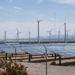 UK launches Global Clean Power Alliance at G20 Summit Wind turbines stand behind sun panels in a dry area of land. The UK launched its Global Clean Power Alliance at the G20 Summit