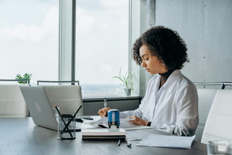 A woman sits at her desk with her laptop while working on her ESOS Action Plan in time for the 5 March 2024 deadline