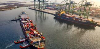 UK government sets six principles for voluntary carbon and nature market integrity Three small tugboats guide a large cargo ship to the dock