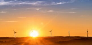 Government unveils Clean Power Action Plan to achieve 2030 energy goals The sun sets on the horizon, outlining wind turbines on the crest of a hill