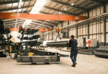 UK Government launches Steel Council to secure industry’s low-carbon future A man works in a manufacturing warehouse moving steel.