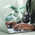 UK government to launch consultation on Sustainability Reporting Standards A man works on his laptop, looking at consultation on Sustainability Reporting Standards