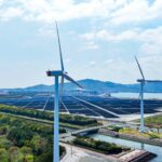 ESG vs. CSR: What’s the difference? A simple guide for UK businesses Aerial view of a hybrid power plant with wind turbines and solar panels