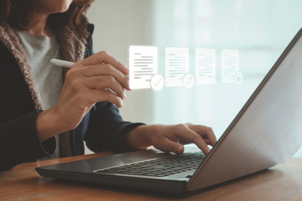 A woman sits at her laptop typing, with images of her screen projected in front of her
