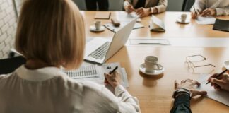New guidance released to align financial and climate transition plans A Woman in White Long Sleeve Shirt Writing on White Paper on Brown Wooden Table