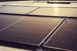 A layer of solar panels from lose up reflects evening sunlight
