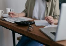 EU delays sustainability reporting requirements for large companies A woman sits at a desk working on her laptop.