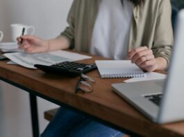 EU delays sustainability reporting requirements for large companies A woman sits at a desk working on her laptop.