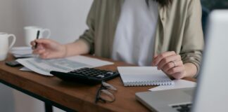 EU delays sustainability reporting requirements for large companies A woman sits at a desk working on her laptop.