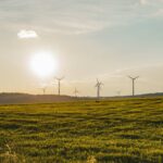 ISO and GHG Protocol announce partnership to harmonise carbon accounting standards Blue sky, green grass and wind turbines
