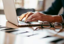 Is SECR working? The results are in A view of a desk with a man in a suit working on a laptop