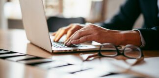 Is SECR working? The results are in A view of a desk with a man in a suit working on a laptop