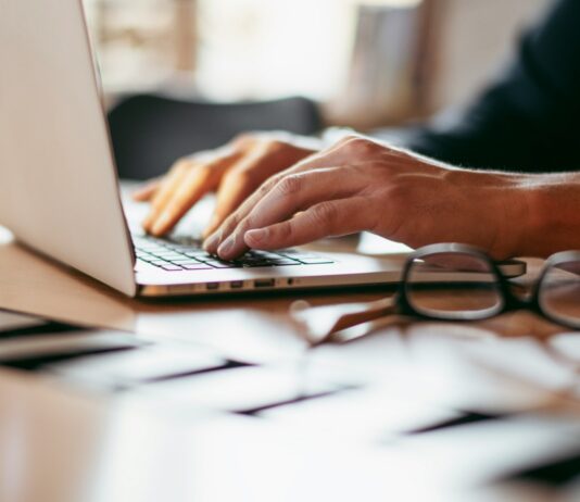 Is SECR working? The results are in A view of a desk with a man in a suit working on a laptop