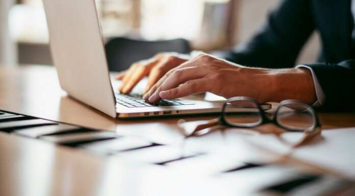 Is SECR working? The results are in A view of a desk with a man in a suit working on a laptop