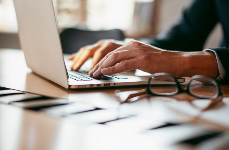 Is SECR working? The results are in A view of a desk with a man in a suit working on a laptop