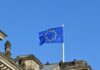 Omnibus I Directive published in EU Official Journal confirming CSRD and CS3D changes European flag flying against a blue sky