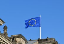 Omnibus I Directive published in EU Official Journal confirming CSRD and CS3D changes European flag flying against a blue sky
