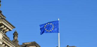 Omnibus I Directive published in EU Official Journal confirming CSRD and CS3D changes European flag flying against a blue sky